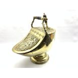 Victorian brass helmet shaped coal scuttle having embossed decoration with turned wooden handle and