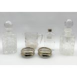 Two square cut glass spirit decanters, set of four Italian glass coasters with plated rims, moulded