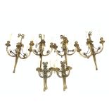 Set of four Regency design brass three branch wall lights with tied bow finials, oval back plates wi