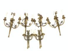 Set of four Regency design brass three branch wall lights with tied bow finials, oval back plates wi