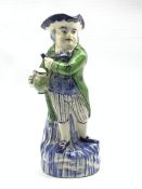 Continental Toby jug modelled as a standing figure wearing a green coat holding a jug of ale and a c