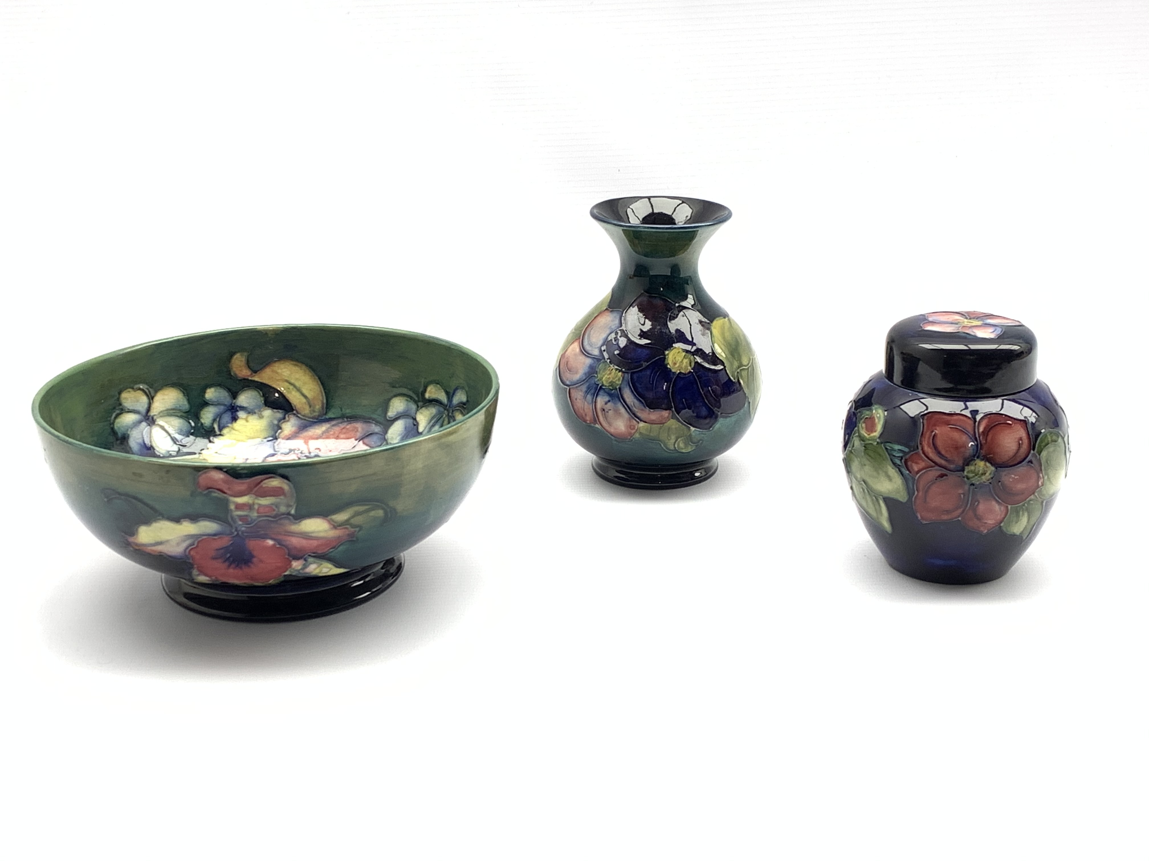 Moorcroft Orchid pattern bowl on green ground, D19cm and Moorcroft vase and ginger jar decorated in