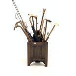 Oak corner stick stand containing various sticks, riding crop and whip, Greek stick with horses head