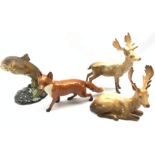 Beswick model of a Standing Stag No. 981, another of a Lying Stag No. 954, another of a Fox No. 1016