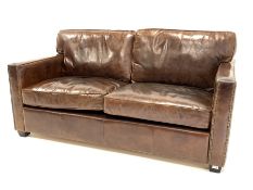 Contemporary two seat sofa upholstered in brown leather, raised on block supports, W172cm, H74cm, D