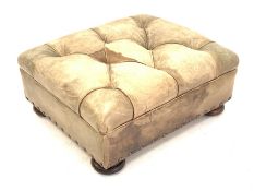 Square leather footstool upholstered in deep buttoned green tan leather, raised on compressed bun s