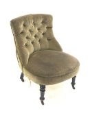 Victorian nursing chair upholstered in buttoned green velvet, raised on turned ebonised supports an