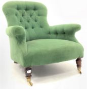 Victorian mahogany framed button back armchair upholstered in green velvet, raised on turned suppor