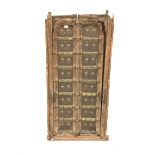 Pair northern Indian teak and metal bound doors, with carved detail and decorative brass studding,