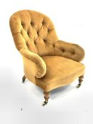 Victorian button back upholstered armchair, raised on turned beech supports and castors, W71cm