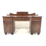 William IV mahogany break bow front sideboard, with raised back over three drawers and two panelled