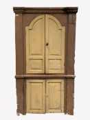 Early 19th century pine corner cupboard, dentil cornice over two arched panelled doors enclosed by