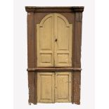 Early 19th century pine corner cupboard, dentil cornice over two arched panelled doors enclosed by