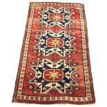 Caucasian style rug, with triple geometric medallion on red field, 112cm x 197cm