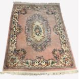 Chinese pink wool ground carpet with floral medallion and scrolled leaf border, 273cm x 400cm