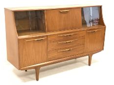 1970s teak sideboard, central fall front flanked by two sets of sliding glass doors, three drawers a