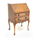 Reproduction mahogany bureau, sloped fall front with fitted interior, two drawers, on shell carved c