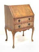 Reproduction mahogany bureau, sloped fall front with fitted interior, two drawers, on shell carved c