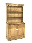 Victorian pine dresser, two heights plate rack above double panelled cupboard, plinth base, W109cm,