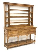 Early 20th century polished pine dresser with associated plat rack, three drawers above potboard bas
