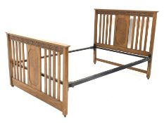 Early 20th century oak 4' 6'' double bedstead, with geometric carved frieze above quarter book match