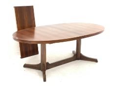 Mid 20th century hardwood veneer extending dining table, the oval top raised on two turned pedestals