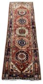 Unusual Persian runner rug, red ground field with five medallions and decorated with stylised flower