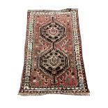 Persian hand knotted red ground rug with double pole medallion, field decorated with stylised motifs