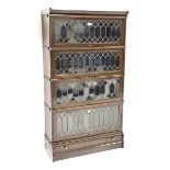 Early 20th century oak four tier stacking library bookcase enclosed by lead glazed doors, drawer to