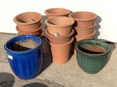 Twelve circular terracotta plant pots (D34cm, H30cm) and two glazed terracotta plant pots