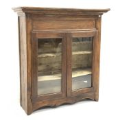 19th century French oak and walnut armoire, projecting cornice over to glazed doors enclosing two sh