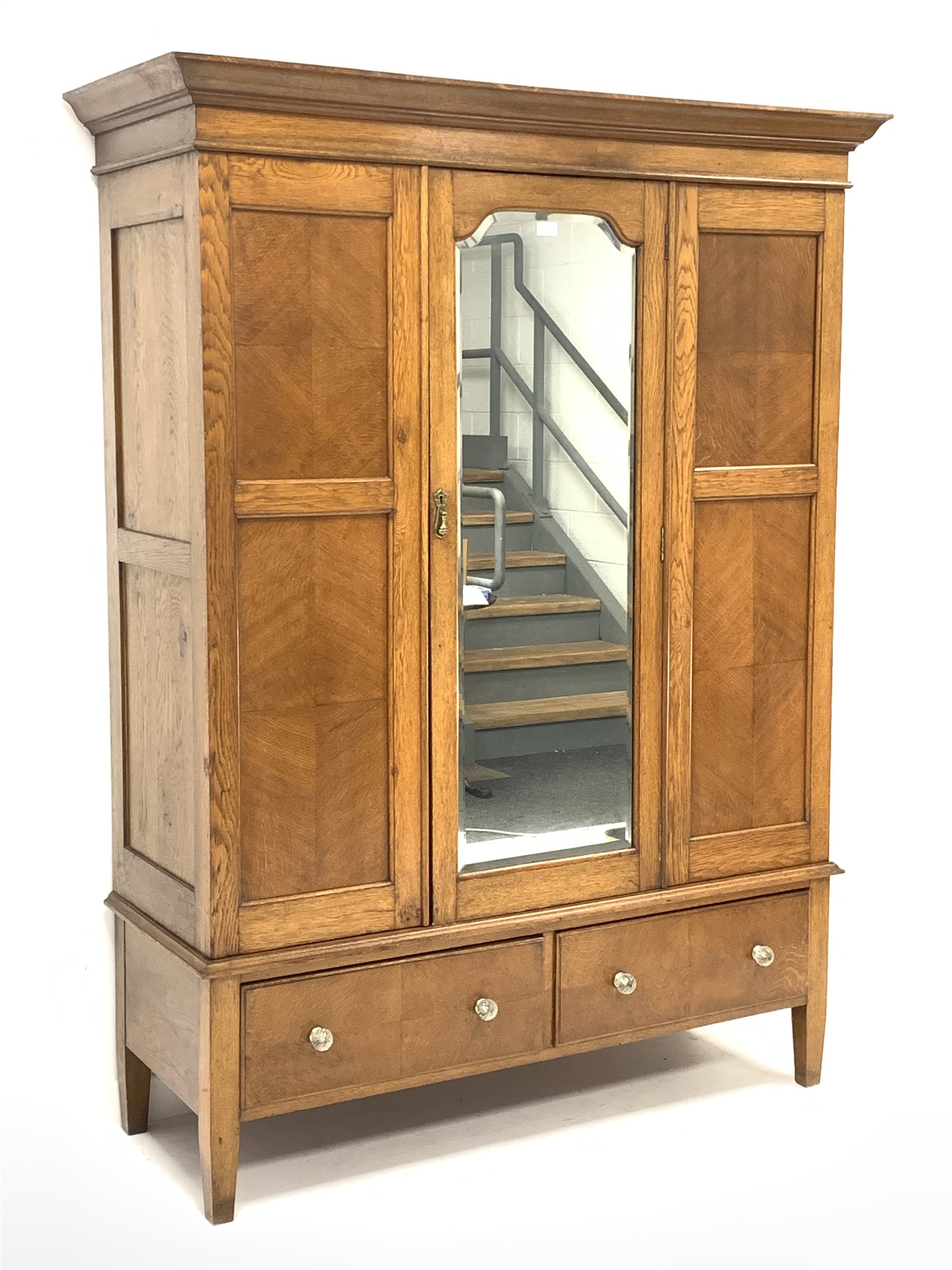 Early 20th century panelled oak wardrobe, projecting cornice over single bevel edged mirror glazed d