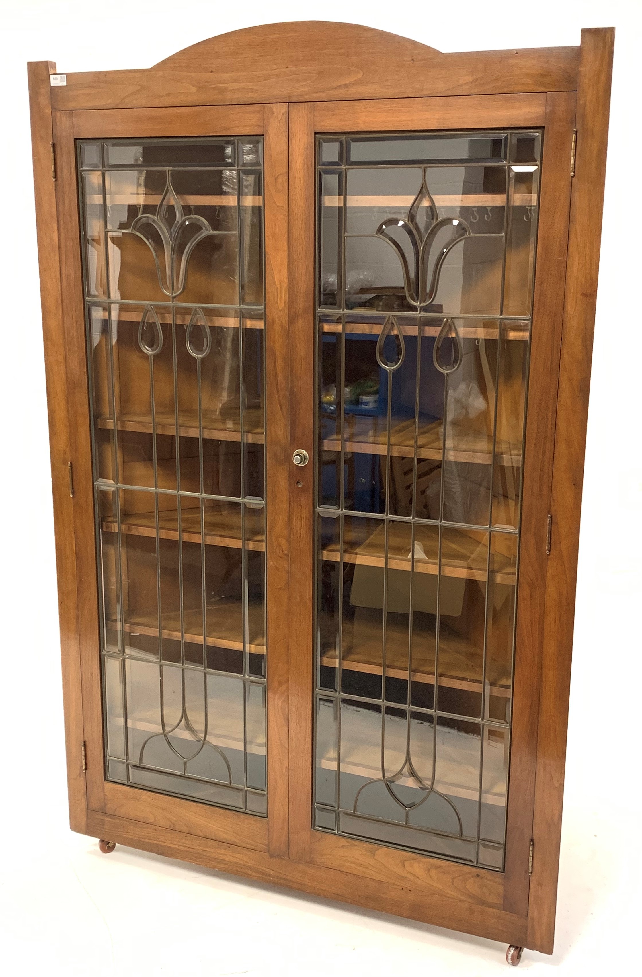 Early 20th century American walnut floor standing corner cupboard, with arched pediment over two cop