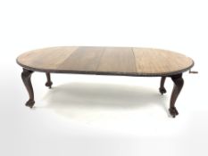 Early 20th century mahogany extending dining table, the oval top with floral edging over acanthus ca
