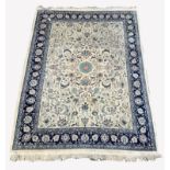 Large Persian design ivory and blue ground carpet, central medallion surrounded by interlaced traili