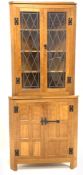 'Eagleman' oak corner cupboard, with led glazed doors enclosing three shelves, panelled doors under