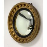 19th century circular gilt framed wall mirror, with convex plate enclosed by reeded ebonised slip, f