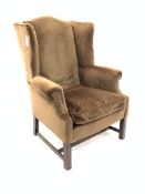 Georgian design wing back armchair, upholstered in brown velvet with loose cushion, raised on square