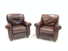 Pair of contemporary reclining club armchairs, upholstered in brown leather, raised on turned staine