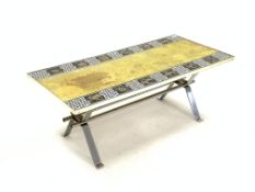 mid 20th century glass toped coffee table, decorated with the signs of the Zodiac, raised on chromed