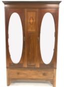 Edwardian inlaid mahogany double wardrobe, two oval mirrored doors enclosing interior fitted for han