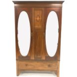 Edwardian inlaid mahogany double wardrobe, two oval mirrored doors enclosing interior fitted for han