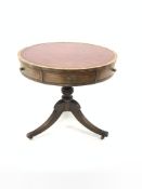 Regency style walnut drum table, with tooled red leather inset top over four drawers and four faux d