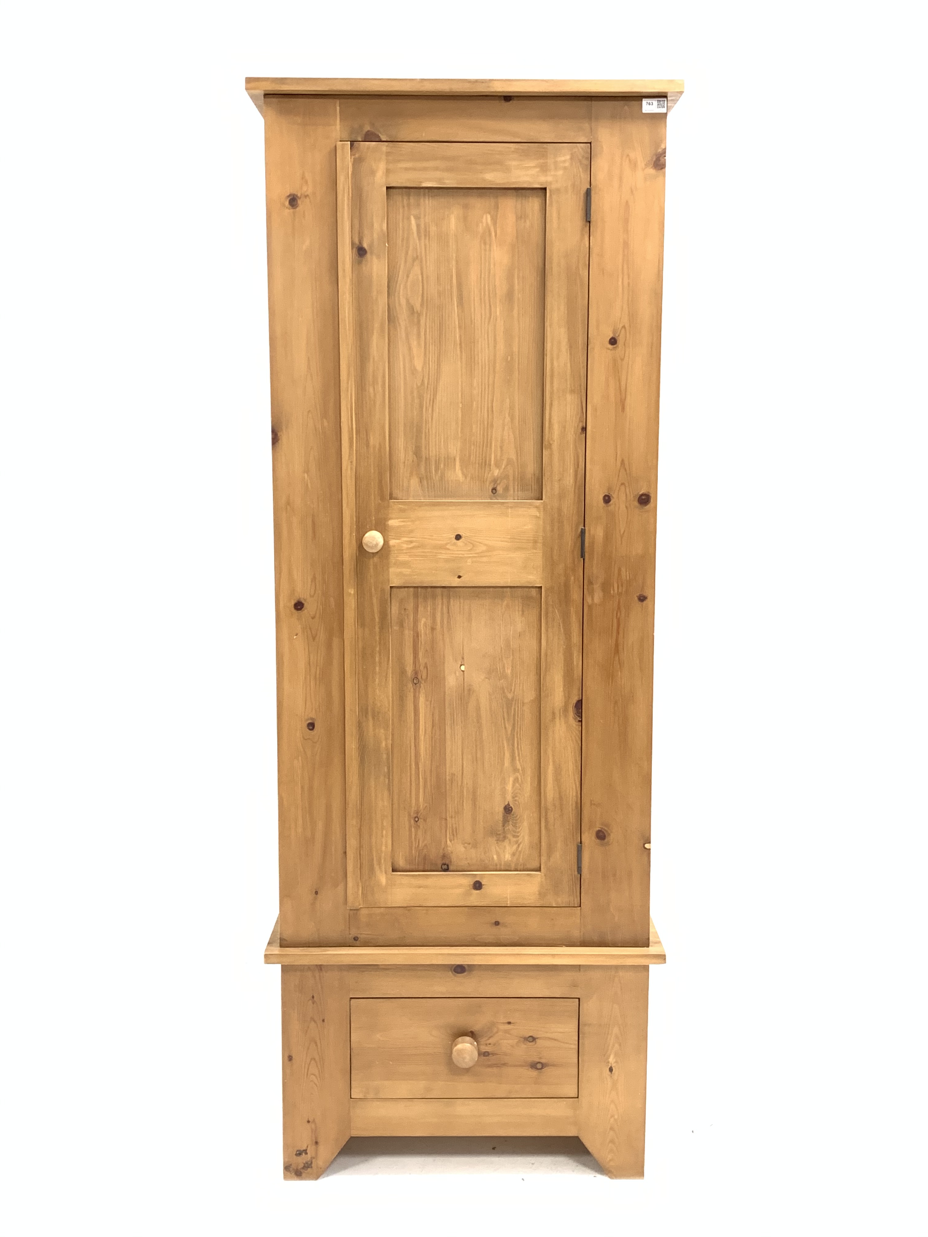 Narrow pine single wardrobe, panelled door enclosing interior fitted with hanging rail, over drawer,