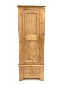 Narrow pine single wardrobe, panelled door enclosing interior fitted with hanging rail, over drawer,