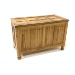 'Eagleman' oak blanket box, with eight panelled hinged lid over four panelled front carved with line