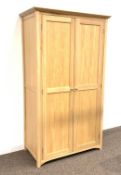 Contemporary solid oak double wardrobe, with panelled doors enclosing interior fitted for hanging, (