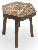 Teak hexagonal table, the top carved with star of David and floral embellishment, raised on four cha