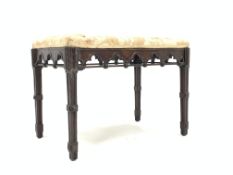 Victorian mahogany duet stool of Gothic design, with upholstered seat over arch carved apron, raised