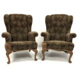 Pair of Queen Anne style wing back upholstered armchairs, raised on shell carved walnut cabriole fro